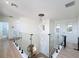Upstairs hallway with modern light fixture, glass railings, and arched windows for lots of natural light at 3841 Golden Knot Dr, Kissimmee, FL 34746