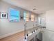 Bright hallway featuring a glass railing and natural light from a window at 3841 Golden Knot Dr, Kissimmee, FL 34746