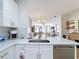 Kitchen with white cabinetry, stainless steel sink, and a view of the open-concept dining area at 3841 Golden Knot Dr, Kissimmee, FL 34746