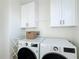 Laundry room featuring side-by-side washer and dryer and storage cabinets at 3841 Golden Knot Dr, Kissimmee, FL 34746