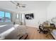 Bright main bedroom featuring a TV, hardwood floors, a work desk, and many windows at 3841 Golden Knot Dr, Kissimmee, FL 34746