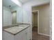 Bathroom with granite countertop, white cabinets, and a large mirror at 386 Marion Oaks Trl, Ocala, FL 34473