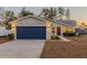 Single-story house with a navy blue garage door and well-manicured lawn at 386 Marion Oaks Trl, Ocala, FL 34473