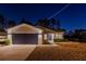 Night view of a single-story home with a dark blue garage door at 386 Marion Oaks Trl, Ocala, FL 34473