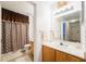 Well-lit bathroom vanity and sink area complemented by a framed mirror and patterned shower curtain at 4000 San Gallo Dr # 102, Kissimmee, FL 34741