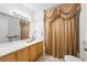 Bathroom with a shower/tub combination featuring a decorative curtain and a light wood vanity at 4000 San Gallo Dr # 102, Kissimmee, FL 34741