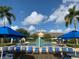 Community pool featuring umbrellas, lounge chairs, and clear blue skies, perfect for relaxation at 4000 San Gallo Dr # 102, Kissimmee, FL 34741