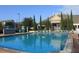 Large community pool with lounge chairs, umbrellas, and a beautiful building in the background at 4000 San Gallo Dr # 102, Kissimmee, FL 34741