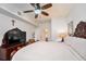 Spacious Primary bedroom featuring a large bed, wooden furniture, a ceiling fan, and adjacent bathroom and closet at 4000 San Gallo Dr # 102, Kissimmee, FL 34741