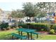 Community picnic area with a green picnic table, grill, and view of townhomes at 4000 San Gallo Dr # 102, Kissimmee, FL 34741