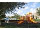 Community playground featuring colorful play structures and a nearby swimming pool with blue umbrellas at 4000 San Gallo Dr # 102, Kissimmee, FL 34741