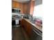 Galley kitchen with wood cabinets, granite counters, and stainless steel appliances at 428 Sand Lime Rd, Winter Garden, FL 34787