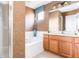 Bathroom with a garden tub, shower, and wood cabinets at 4525 Stella St, Kissimmee, FL 34746