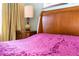 Comfortable bedroom with wooden bed frame and plush purple bedding at 4525 Stella St, Kissimmee, FL 34746