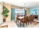Dining room with a wooden table and chairs, featuring lake views and teal curtains at 4525 Stella St, Kissimmee, FL 34746