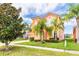 Two-story house with orange stucco and tile roof, showcasing a manicured lawn and palm trees at 4525 Stella St, Kissimmee, FL 34746