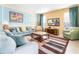 Spacious living room with light blue sofas, a large TV, and a patterned rug at 4525 Stella St, Kissimmee, FL 34746