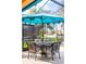 Covered patio with teal umbrella, table, and four chairs for outdoor dining at 4525 Stella St, Kissimmee, FL 34746