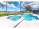 Inviting pool and spa with screened enclosure, offering scenic water views at 4525 Stella St, Kissimmee, FL 34746
