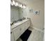 Bright bathroom featuring double sinks, white cabinets, and beach-themed decor at 4976 Windermere Ave, Kissimmee, FL 34746