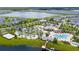 Aerial view of the community pool area with lazy river, clubhouse, and lush landscaping near a lake at 4976 Windermere Ave, Kissimmee, FL 34746