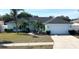 Light teal house with a two-car garage and palm trees at 509 Drayton Rd, Winter Haven, FL 33884