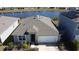 Aerial view of a single-story house with a white garage door and a lake behind it at 522 Noble Ave, Davenport, FL 33837