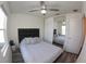 Bright bedroom featuring a ceiling fan, closet with mirrored doors, and sleek gray wood flooring at 697 Stoney Point Cir, Davenport, FL 33896