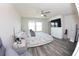 Bedroom featuring a ceiling fan, large windows, flat-screen TV, chair, and vinyl flooring at 697 Stoney Point Cir, Davenport, FL 33896