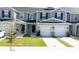 Well-maintained townhome exterior with two-car garage, inviting front entrance and manicured lawn at 697 Stoney Point Cir, Davenport, FL 33896