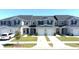 Well-maintained gray townhomes feature attached garages, green lawns, and matching shutters at 697 Stoney Point Cir, Davenport, FL 33896