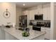 Modern kitchen featuring stainless steel appliances, granite countertops, and white cabinets, perfect for cooking at 697 Stoney Point Cir, Davenport, FL 33896