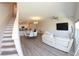 Open floor plan with stairs, gray floors, white walls, and modern furniture at 697 Stoney Point Cir, Davenport, FL 33896
