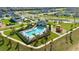 Aerial view of a community pool and playground with surrounding modern homes in a well-maintained neighborhood at 697 Stoney Point Cir, Davenport, FL 33896