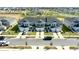 Aerial view of the gray townhomes featuring attached garages, black shutters, and community pool in the background at 697 Stoney Point Cir, Davenport, FL 33896