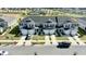 Aerial view of the gray townhomes featuring attached garages, black shutters, and a well-maintained lawn at 697 Stoney Point Cir, Davenport, FL 33896