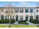 Front view of charming townhouses with green doors and landscaping at 709 Centervale Dr, Celebration, FL 34747
