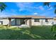 Exterior view of a home's backyard with a covered patio and green lawn at 827 Albi Ct, Kissimmee, FL 34759