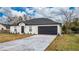 Newly constructed home with a gray roof, white exterior, and a dark gray garage door at 937 Elkcam Blvd, Deltona, FL 32725