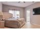 Main bedroom with beige bedding and large TV at 9850 Hidden Dunes Ln, Orlando, FL 32832