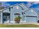 Beautiful blue house with a two-car garage and well-manicured lawn at 9850 Hidden Dunes Ln, Orlando, FL 32832
