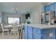 Spacious kitchen with blue cabinets, an island, and Gathering room view at 9850 Hidden Dunes Ln, Orlando, FL 32832