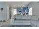 Open living room with gray sectional sofa and view of kitchen at 9850 Hidden Dunes Ln, Orlando, FL 32832