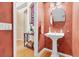 Powder room with pedestal sink and leaf-patterned wallpaper at 1009 Wood Cv, Kissimmee, FL 34743