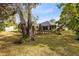 Scenic backyard with lush greenery, privacy fence and a glimpse of the screened in patio at 1150 Eden Dr, St Cloud, FL 34771