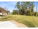 Expansive backyard with mature trees and a glimpse of the house and screened in patio at 1150 Eden Dr, St Cloud, FL 34771