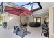 Spacious screened patio with hot tub, grill, seating area, and an umbrella for shade at 1150 Eden Dr, St Cloud, FL 34771