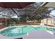 Tranquil pool with screened enclosure surrounded by lush foliage and mature trees at 1150 Eden Dr, St Cloud, FL 34771
