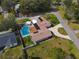 Aerial view of a home featuring a private backyard pool, lush landscaping, and a circular driveway at 123 Lakeview Dr, Auburndale, FL 33823