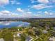Beautiful lakefront property with lush greenery and stunning water views under a partly cloudy sky at 123 Lakeview Dr, Auburndale, FL 33823